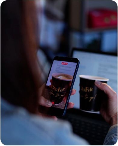 Cliente fotografando com o celular dois copos de café personalizados