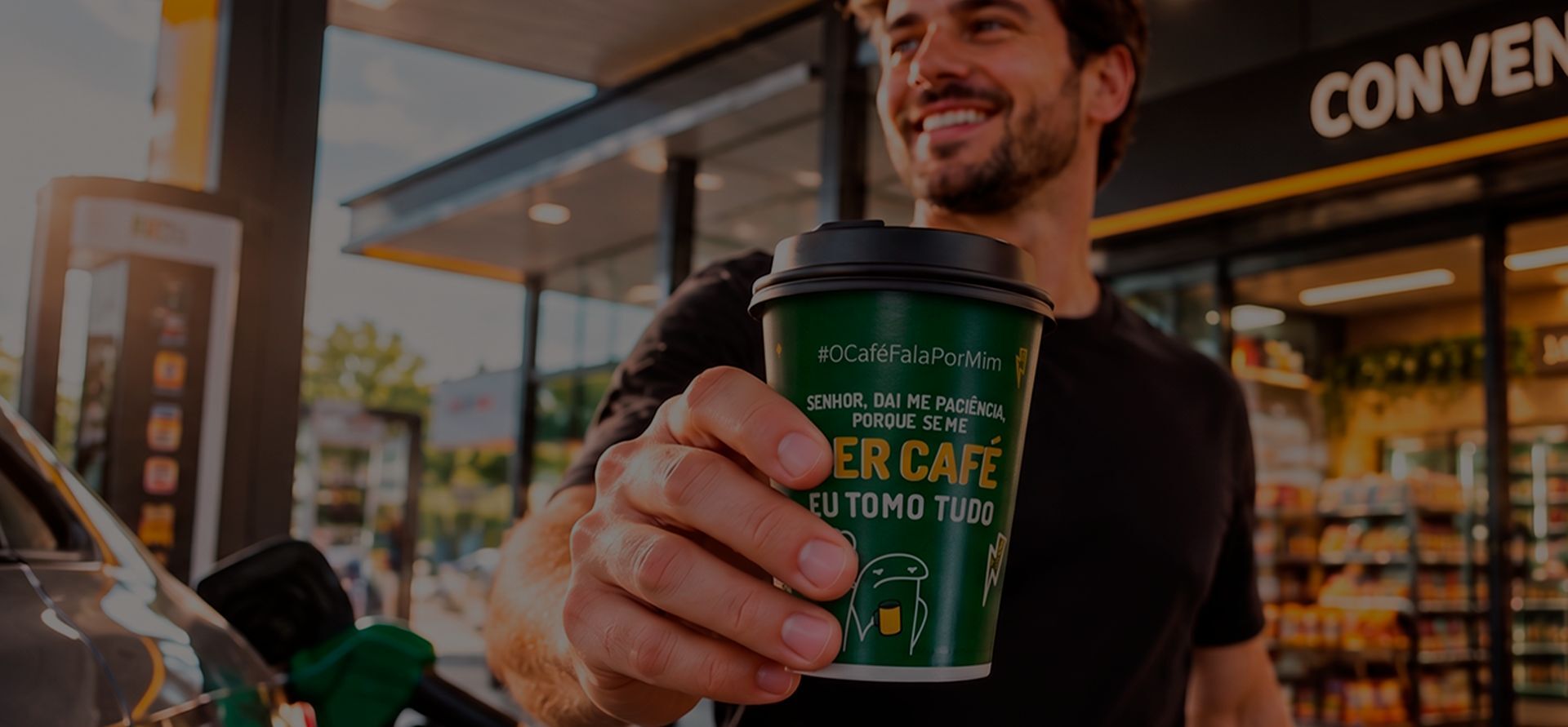 Homem sorrindo e estendendo um copo de café personalizado numa loja de conveniência de posto
